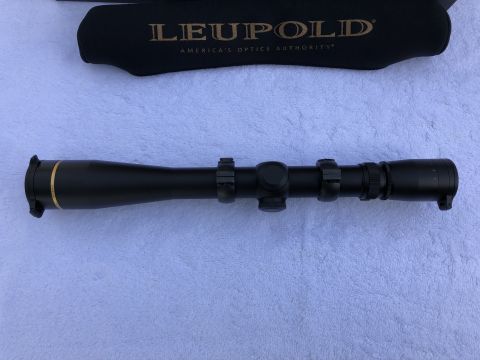 1995 Mercury Grand Marquis - A Leupold rifle scope and its protective cover are displayed on a textured surface.