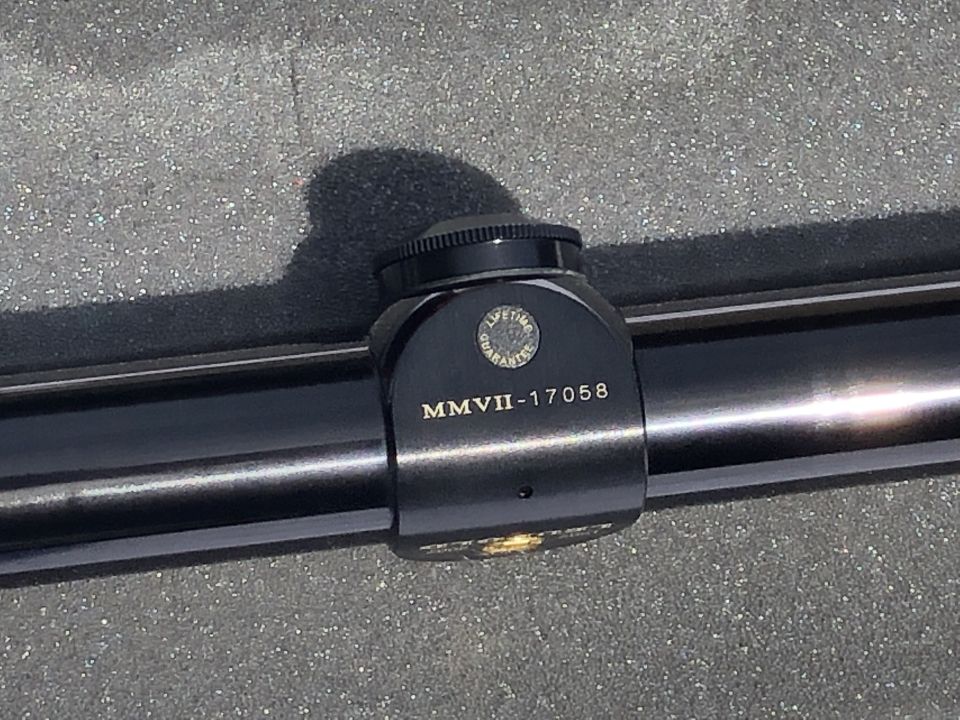 Black scope mount with "MMVII-17058" and "LIFETIME GUARANTEE" text