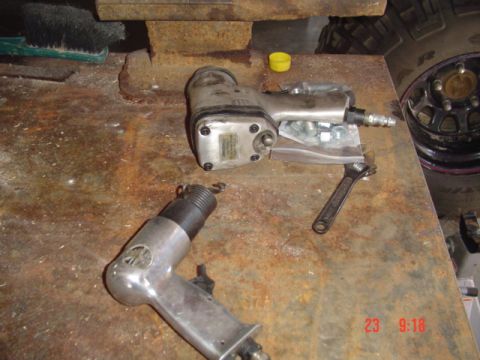1989 Ford Bronco - Tools and hardware laid out on a workbench, with a tire in the background.