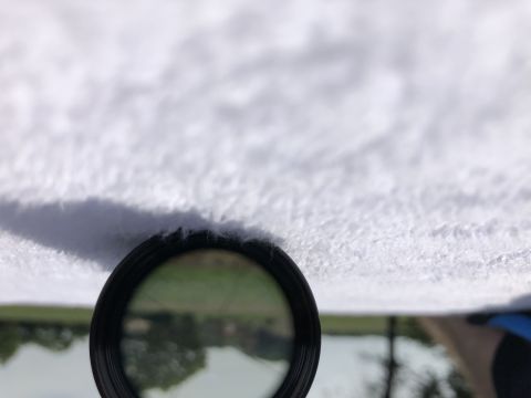 1995 Mercury Grand Marquis - A magnifying glass is held up to the car's headliner, revealing a reflection of the outside scenery.