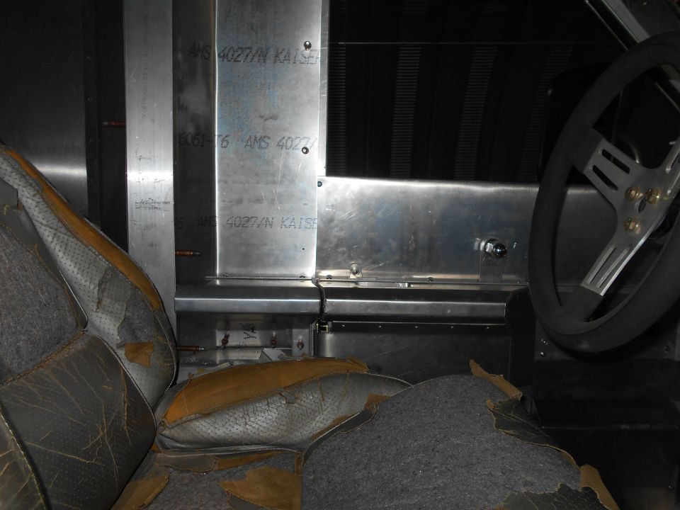 Interior view of worn seats and metal paneling with text 'AMS 4027/N KAISER'