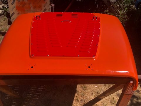 1992 Jeep Wrangler - A freshly painted orange Jeep Wrangler hood is shown, a red insert with ventilation slots.