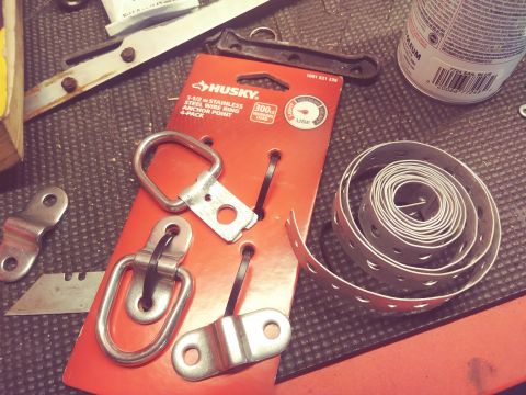 1996 Ford Bronco - A collection of tie-down hardware, including anchor points and strapping, is laid out on a textured surface.