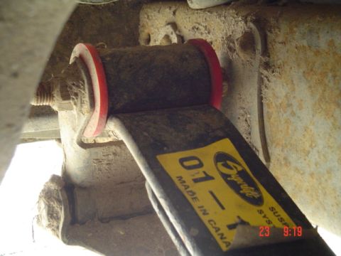 1989 Ford Bronco - Close-up of a vehicle's suspension part, showing a leaf spring with red bushings and a Superlift sticker.