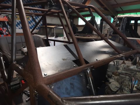 1985 Toyota Hilux - The interior of a custom-built vehicle with a prominent roll cage and exposed engine components.