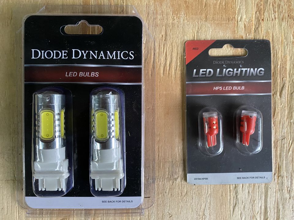 Two packages of Diode Dynamics LED bulbs, one white and one red.