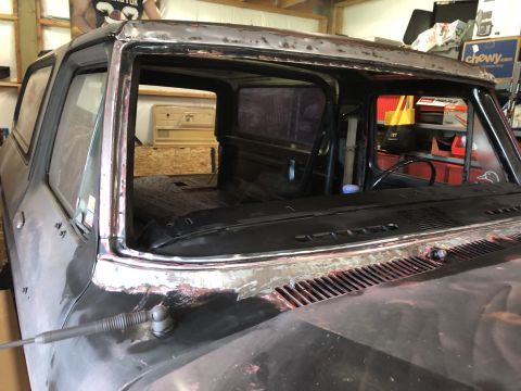 1978 Ford Bronco - Close-up view of the windshield frame of a vintage vehicle undergoing restoration. The metal around the windshield opening has been ground…