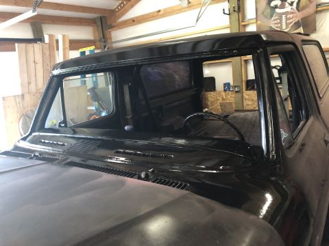 1978 Ford Bronco - The front section of a black classic truck or SUV is shown, with the windshield frame and part of the hood visible. The vehicle appears to…