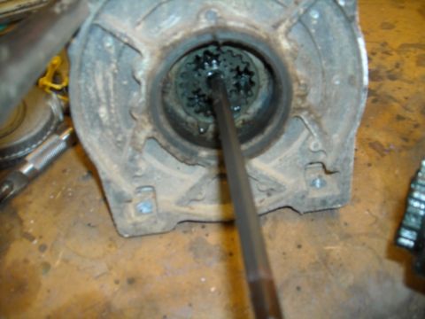 1992 Jeep Wrangler - A close-up view shows a tool inserted into a splined gear assembly within a rusty, circular housing. The housing is dirty and appears to be…