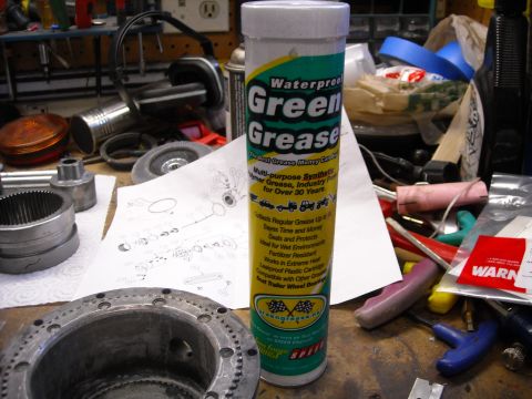 1992 Jeep Wrangler - A tube of Green Grease waterproof synthetic multi-purpose grease sits on a workbench next to various tools and mechanical parts, including…