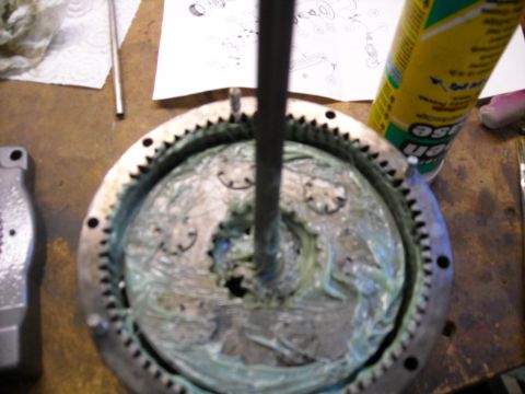 1992 Jeep Wrangler - A close-up view shows a greased planetary gear set with a central shaft extending upwards. A can of lubricant and technical diagrams are vi…