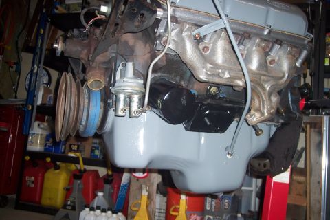 1978 Ford Bronco - A close-up view of a rebuilt Ford V8 engine, painted gray, with a new black oil filter and fuel pump visible. The engine is mounted on a st…
