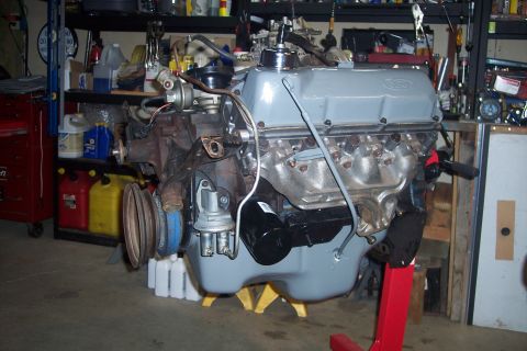 1978 Ford Bronco - A Ford V8 engine, likely from the late 1970s, is mounted on a red engine stand in a garage. The engine features a gray valve cover with a F…