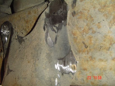 1989 Ford Bronco - Close-up view of a rusty underbody suspension component, possibly related to a shackle flip modification.