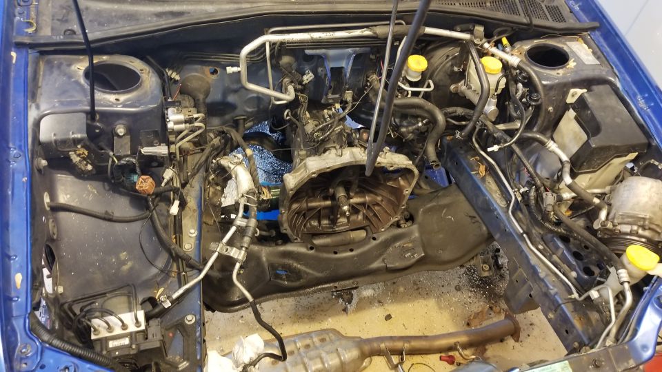 Blue Subaru Impreza engine bay with engine and transmission removed.
