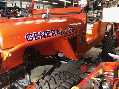 1992 Jeep Wrangler - The side view of an orange Jeep Wrangler is shown, with the text "GENERAL LEE" in blue and white lettering on the fender. The vehicle is in…
