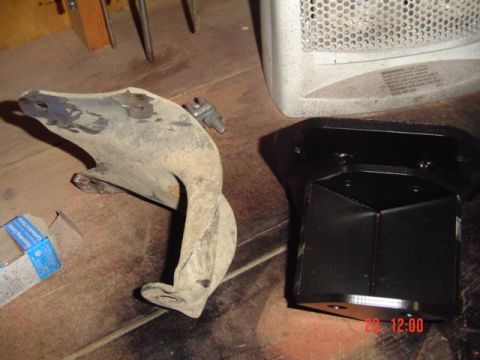 1989 Ford Bronco - Two vehicle suspension components, one old and one new, are displayed on a workbench.