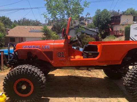 1992 Jeep Wrangler - A bright orange, modified Jeep Wrangler, nicknamed "General Lee", is parked outdoors on a sunny day. The vehicle features large off-road ti…