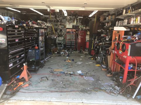 1992 Jeep Wrangler - A cluttered garage workshop with various tools, equipment, and storage units. The space is filled with metal cabinets, welding equipment, a…