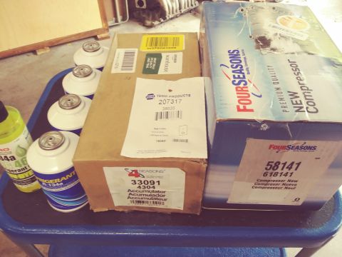 1996 Ford Bronco - Several boxes of automotive parts, including refrigerant cans and two large boxes labeled "Four Seasons" containing new compressors, are ar…