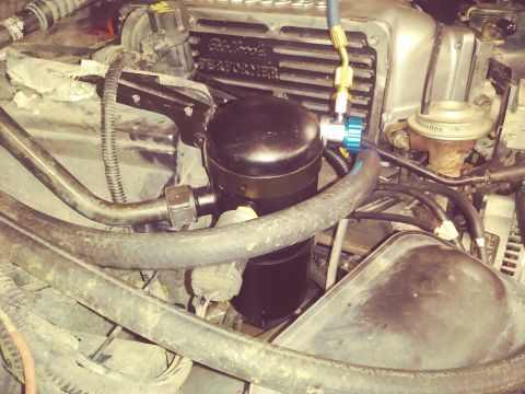 1996 Ford Bronco - Close-up view of the engine bay of a 1996 Ford Bronco, focusing on the air conditioning receiver-drier and surrounding components.