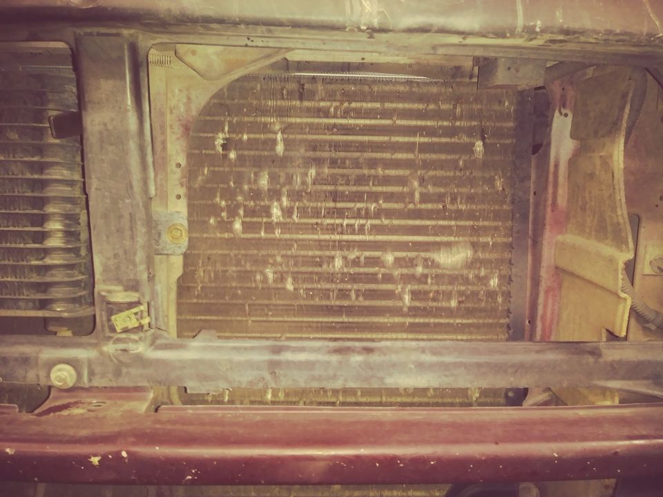 Close-up of a vehicle's radiator and condenser assembly.