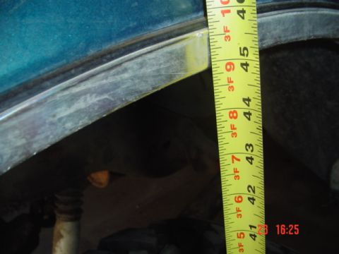 1989 Ford Bronco - A tape measure is used to measure the height of a vehicle's suspension components.