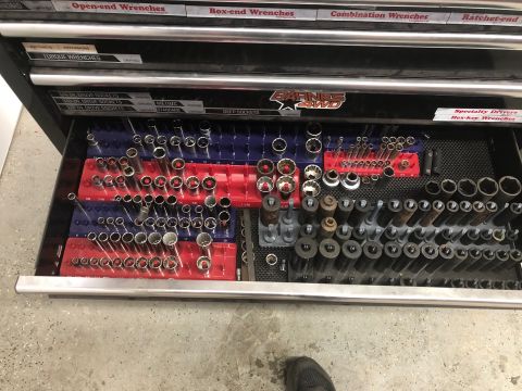 1992 Jeep Wrangler - A top-down view of an open toolbox drawer filled with various sockets and drivers. The drawer is organized with red and blue socket holders…