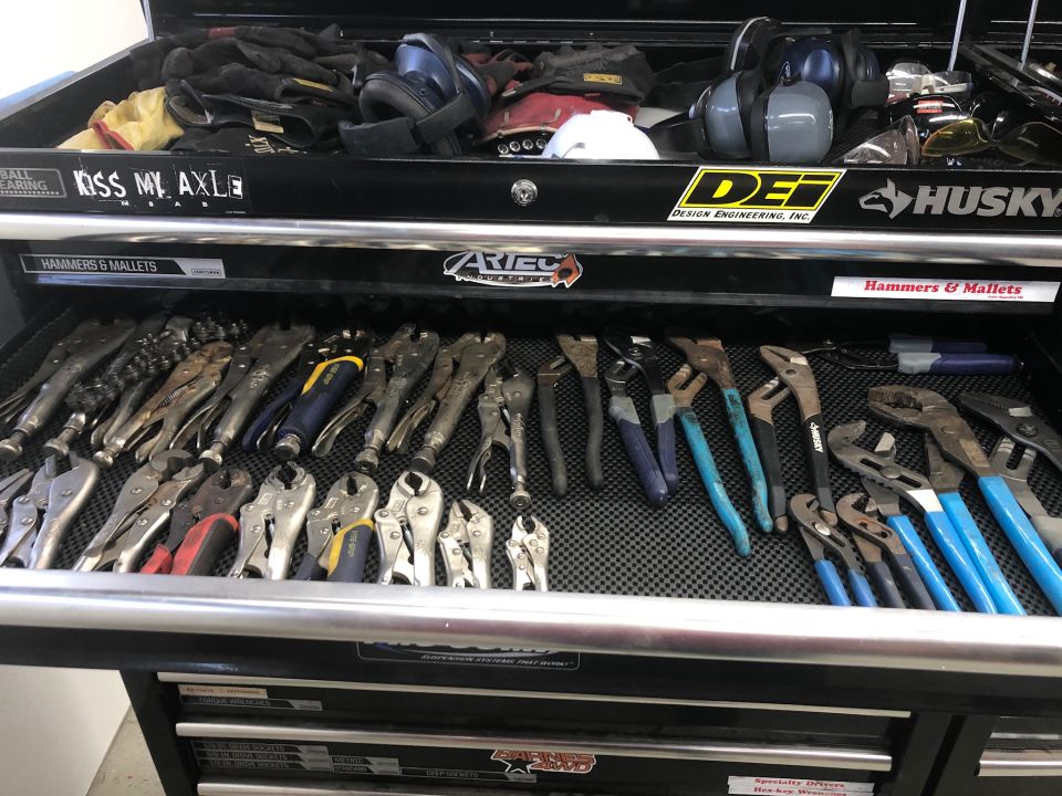 Mechanic's tool chest drawer filled with pliers and wrenches.