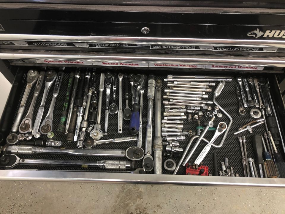Open tool drawer with wrenches, ratchets, and sockets.