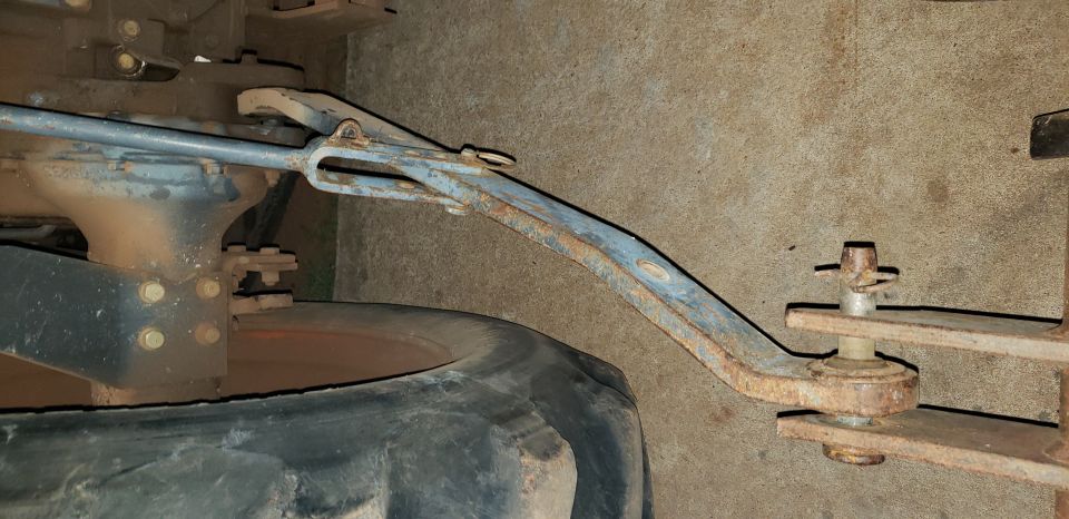 Rusty tractor linkage connected to tire and differential.