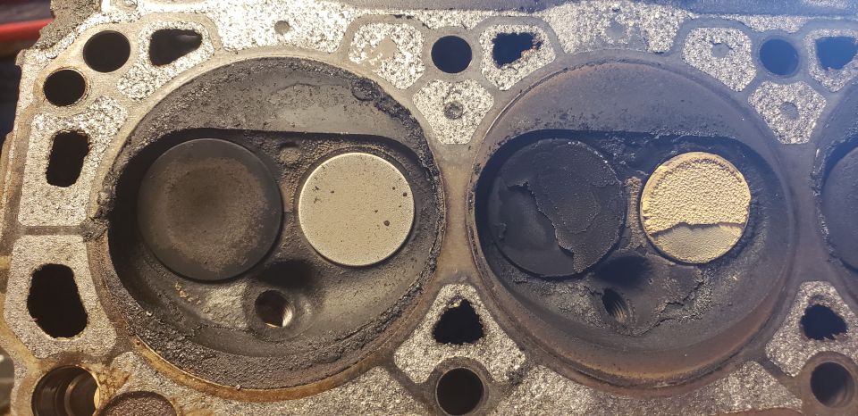 Cylinder head combustion chambers with valves covered in heavy black carbon deposits