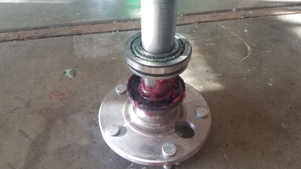 Greased wheel bearing assembly on a silver hub with bolts.