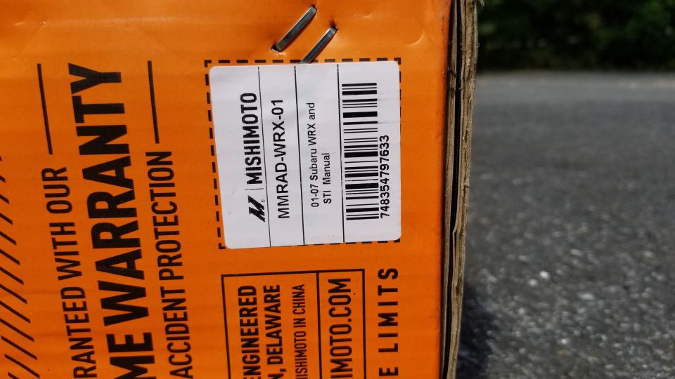 Orange box with Mishimoto label for Subaru WRX/STI, warranty info visible.