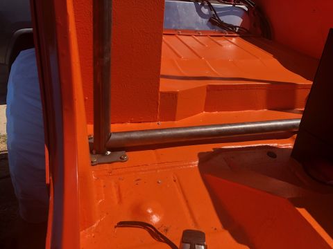 1992 Jeep Wrangler - The interior of an orange Jeep Wrangler shows a roll bar and the bed of the vehicle, which appears to have been recently painted.