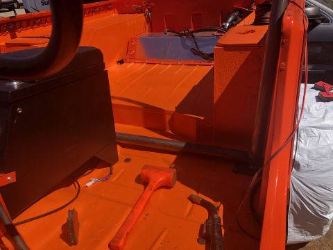 1992 Jeep Wrangler - The interior of an orange Jeep Wrangler is shown with a black seat and various tools scattered on the floor, including a red mallet and a w…
