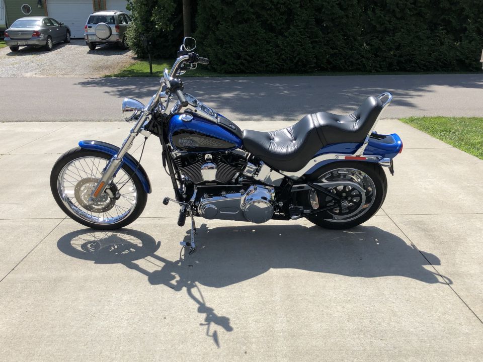 Blue and black Harley-Davidson Softail motorcycle parked on concrete.