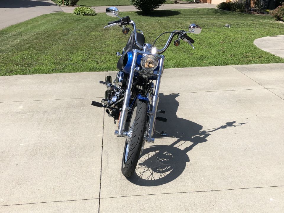 Blue motorcycle front view with chrome handlebars and headlight