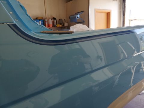 1996 Ford Bronco - A close-up view of the side panel of a light blue vehicle, showing a decorative stripe detail.