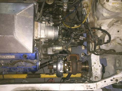1993 Mercury Tracer - Custom turbocharger setup in an engine bay, showing intake manifold and wiring. No year is discernible.
