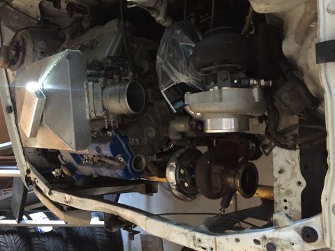 1993 Mercury Tracer - Engine bay modifications with twin turbochargers and intercooler installed on a white vehicle frame.
