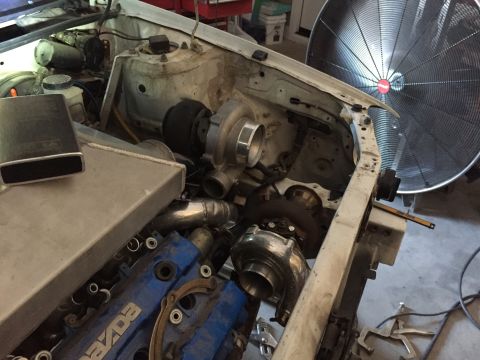 1993 Mercury Tracer - The engine bay is being modified with turbochargers and an intercooler, with a blue Mazda valve cover visible.