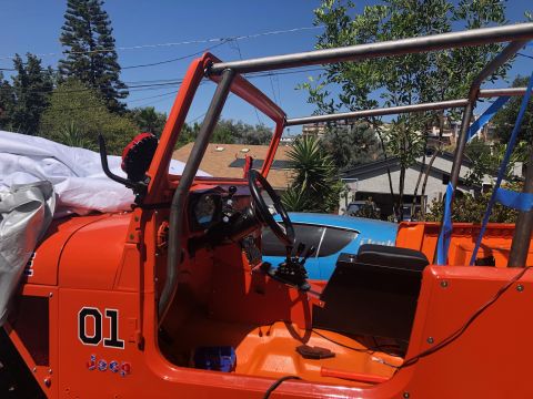 1992 Jeep Wrangler - The interior of an orange Jeep is shown, with a roll cage and the number 01 decal on the side.