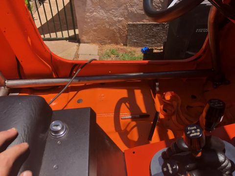 1992 Jeep Wrangler - The interior of an orange Jeep is shown, highlighting the roll cage and shifter mechanism.