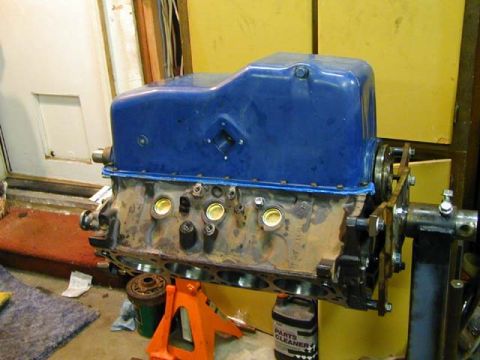 1979 Ford Bronco - A V8 engine block with a blue oil pan is shown on an engine stand, with a can of parts cleaner nearby.