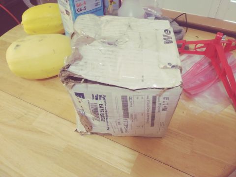1996 Ford Bronco - A damaged shipping box sits on a wooden table next to two spaghetti squash.