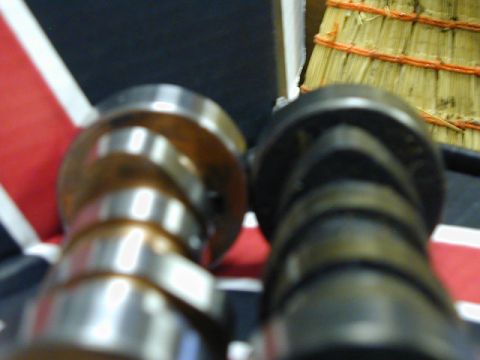 1979 Ford Bronco - Close-up of two camshafts, one appearing new and the other worn, against a backdrop resembling the Union Jack flag.