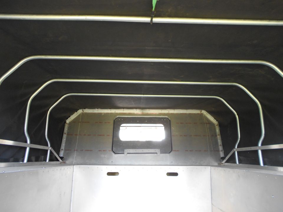 Interior of a custom vehicle build with a roll cage and aluminum paneling.