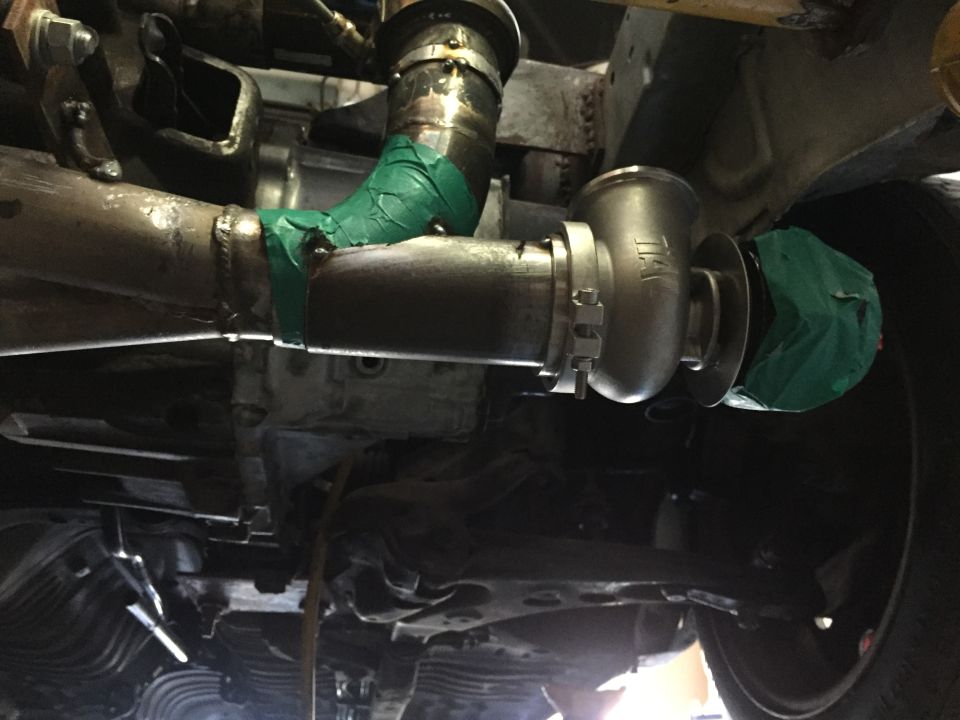 Underside of a car showing a turbocharger and custom exhaust piping.