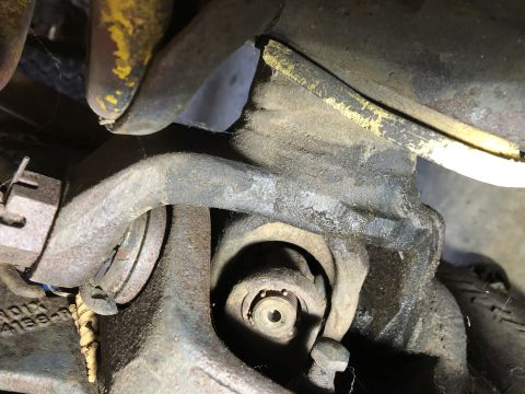 1978 Ford Bronco - A close-up view of a rusty universal joint and surrounding suspension components, likely from a vintage Ford Bronco.